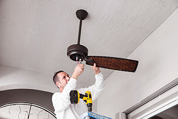Technician rewiring ceiling fan